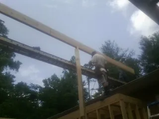 Carpenter setting a ridge beam over a new addition frame — Ice Dam Removal by Roofing Brothers in Sparkill