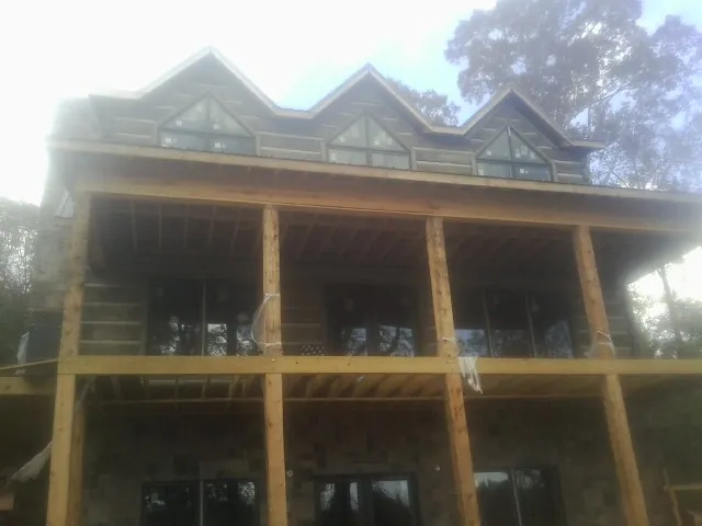 Dormers and porch framing on a large log home under construction — Roof Coating work by our crew in Sparkill