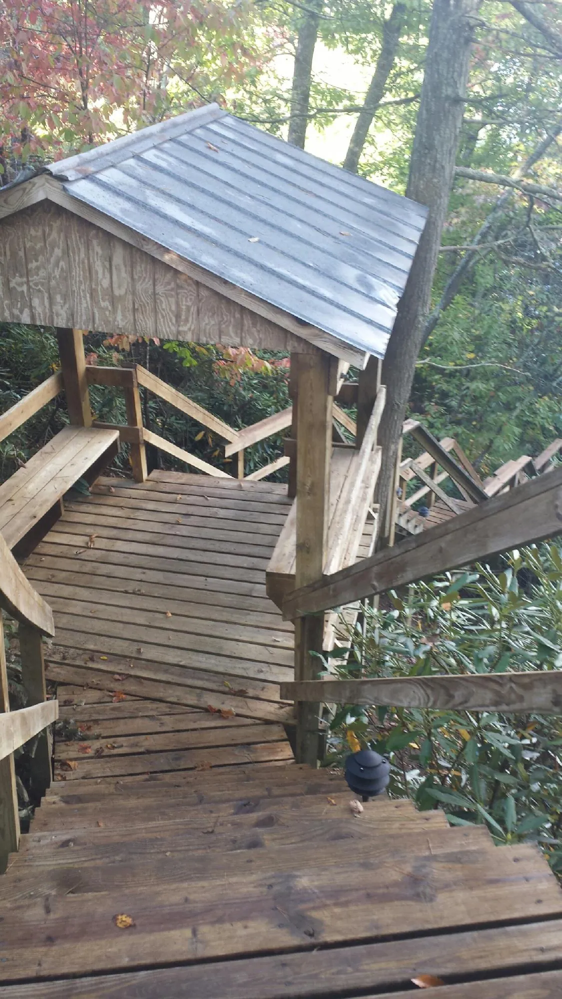 Metal roofed shelter over wooden steps on a wooded walkway — Skylight Repair & Installation work by our crew in Sparkill